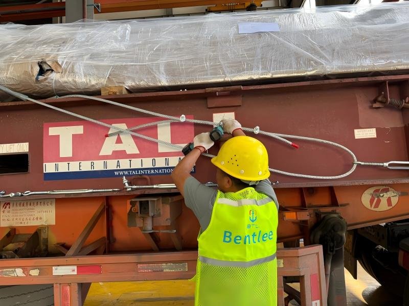 Technician checking lashing tension and contact points before shipment
