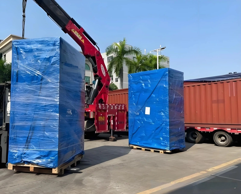 A heavy excavator secured on a flat rack container using industrial chain lashing and tensioning turnbuckles to prevent shifting during ocean freight transport.