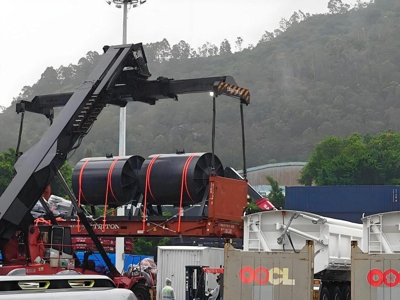 Side view of cargo loaded on a flat rack container (flatrack) at a terminal, showcasing the optimal container type for out-of-gauge cargo to save space and reduce freight rates.