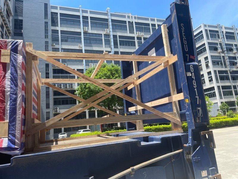 Rear perspective of wooden blocking and cross-bracing inside a blue open top container, ensuring cargo stability and preventing shift during heavy weather conditions.