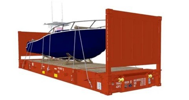 Blue yacht secured inside a red open top shipping container showing internal lashing wires and wooden blocking for marine insurance compliance