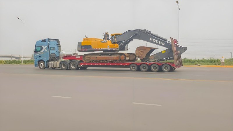 A large piece of industrial machinery securely lashed on a flat rack container, demonstrating its suitability for wide and heavy out-of-gauge (OOG) shipments.