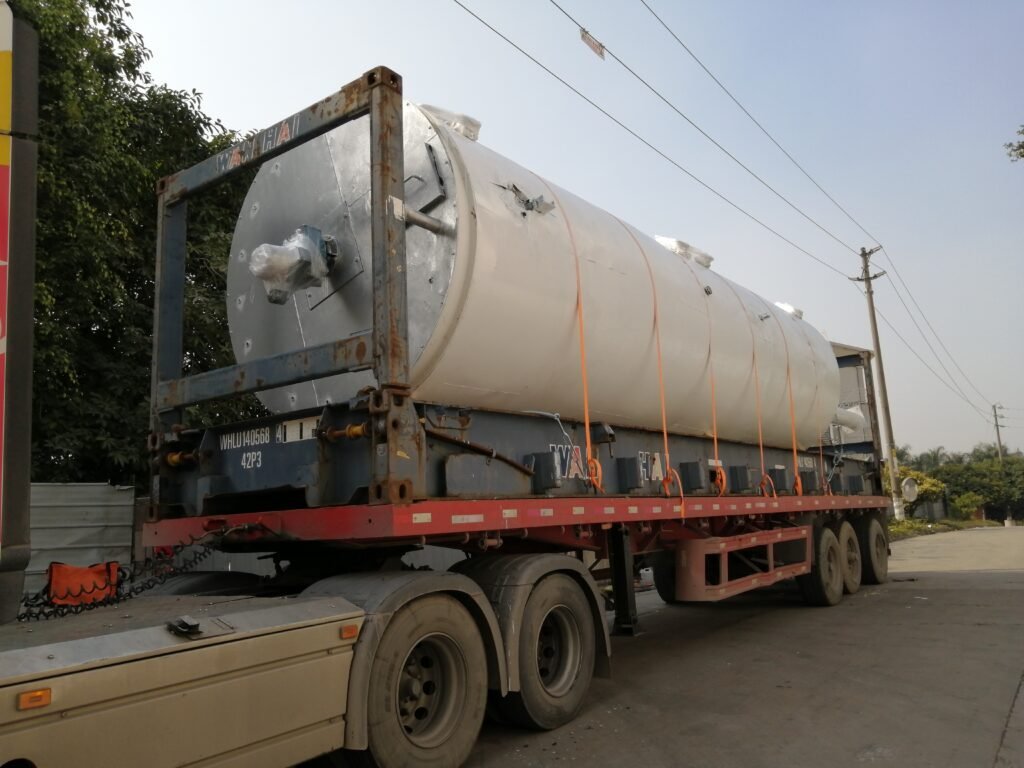 Large stainless steel tank secured with orange straps on a WAN HAI flat rack for sea freight transport