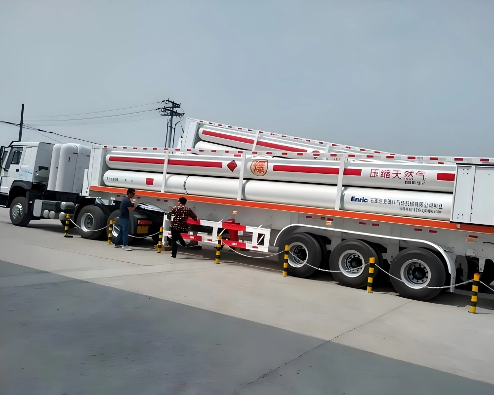 White cylindrical compressed natural gas tanks with red hazard band and English labeling Compressed Natural Gas secured on white multi axle trailer for oil and gas project transport