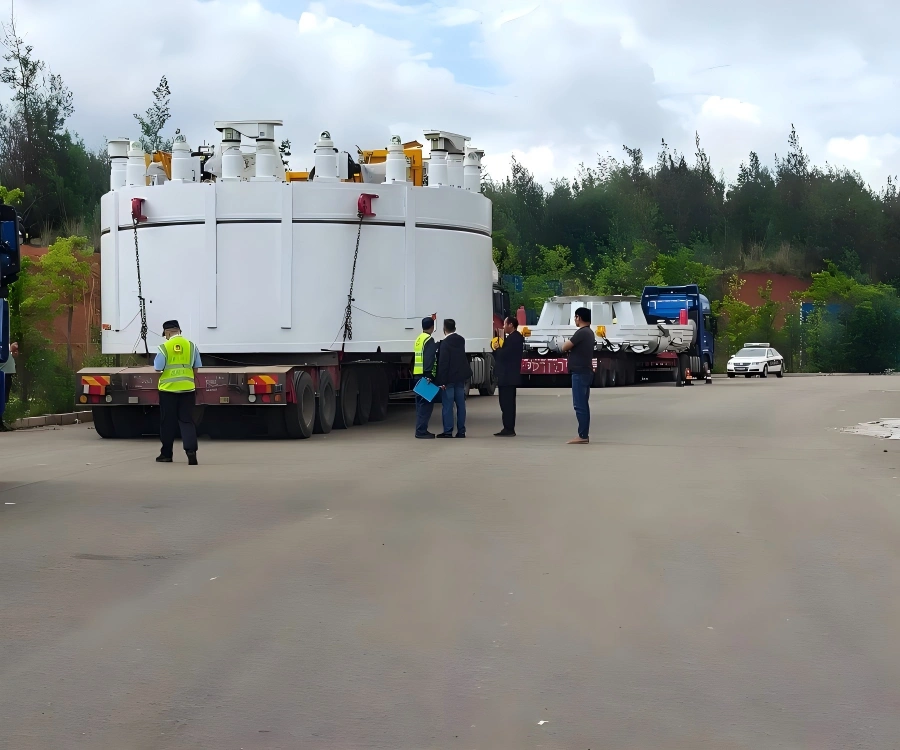 Large white cylindrical mining process module with top mounted valves and instrumentation secured on red ultra low bed trailer for mine plant delivery