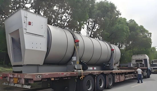 Large grey mining processing unit with hopper inlet and structural supports loaded on red flatbed trailer and secured for remote mine site delivery