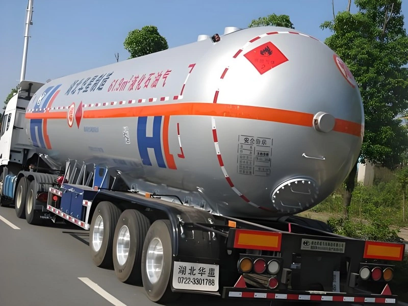 Silver Huaxing LPG semi-trailer with orange hazard stripes and 61.9m³ capacity marking, designed for safe road transport of liquefied petroleum gas