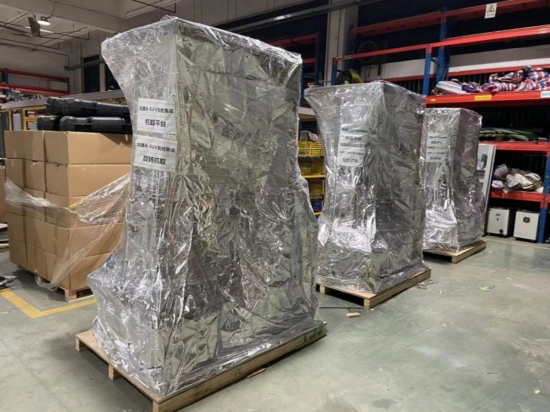 Multiple pieces of industrial machinery are wrapped in vacuum-sealed aluminum foil bags, placed on wooden pallets in a warehouse, providing superior moisture and corrosion protection for export.