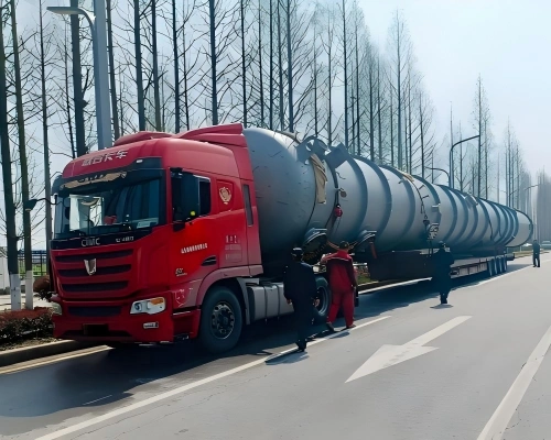 Long industrial tank transported on multi-axle lowbed trailer, illustrating inland movement phase of open top/OOG project cargo logistics