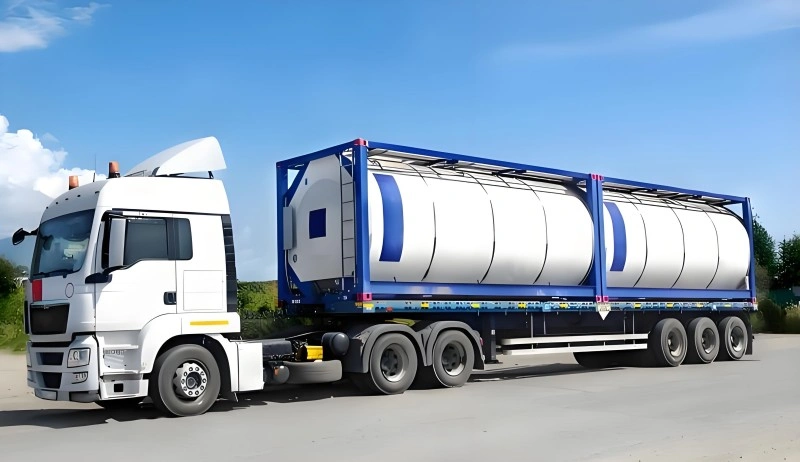 white truck transporting a large ISO tank container equipped with IoT sensors for real-time monitoring of oversized cargo during multimodal transport.