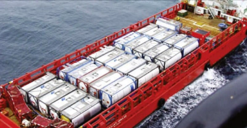 n aerial view of a red cargo ship carrying multiple white LNG (Liquefied Natural Gas) tank containers. The containers are securely fastened on the deck, showcasing a method for maritime transport of cryogenic liquids.