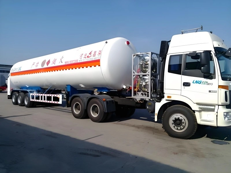 A white LNG (Liquefied Natural Gas) transport truck with a large cylindrical tank, featuring orange hazard stripes and Chinese characters indicating its use for transporting liquefied natural gas. The truck is parked in an industrial area under a clear blue sky.