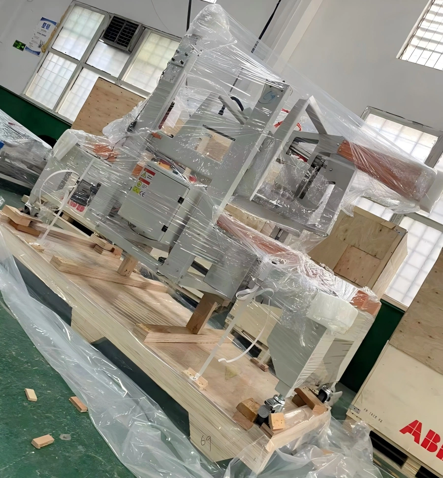 Precision machinery secured on wooden skid and wrapped in multi-layer stretch film with corner guards and tension straps for vibration protection