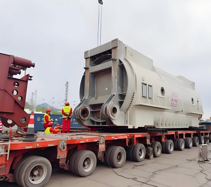 White engineered industrial module loaded on multi-axle modular trailer, with crew verifying lashing and alignment before dispatch