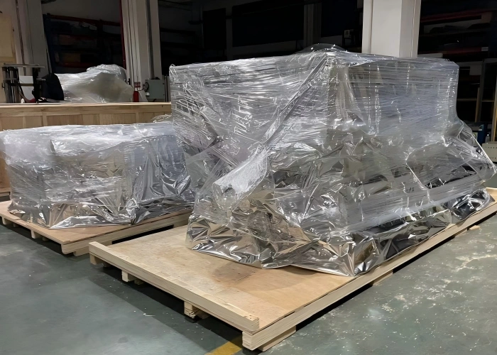 Two export cargo units on pallets protected by multi-layer vacuum compatible film including transparent and metallized layers for long transit