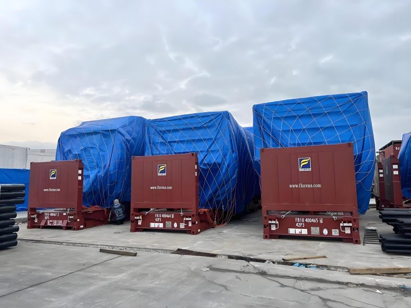 Red open-top containers with blue tarp-covered tall cargo — full sidewalls, bows & tarp provide lateral support and weather protection.