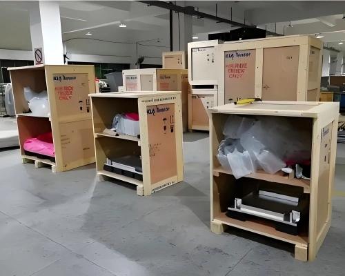 Open wooden cases branded KIA Temcor holding protected equipment with foam padding and shrink wrap for sensitive cargo export