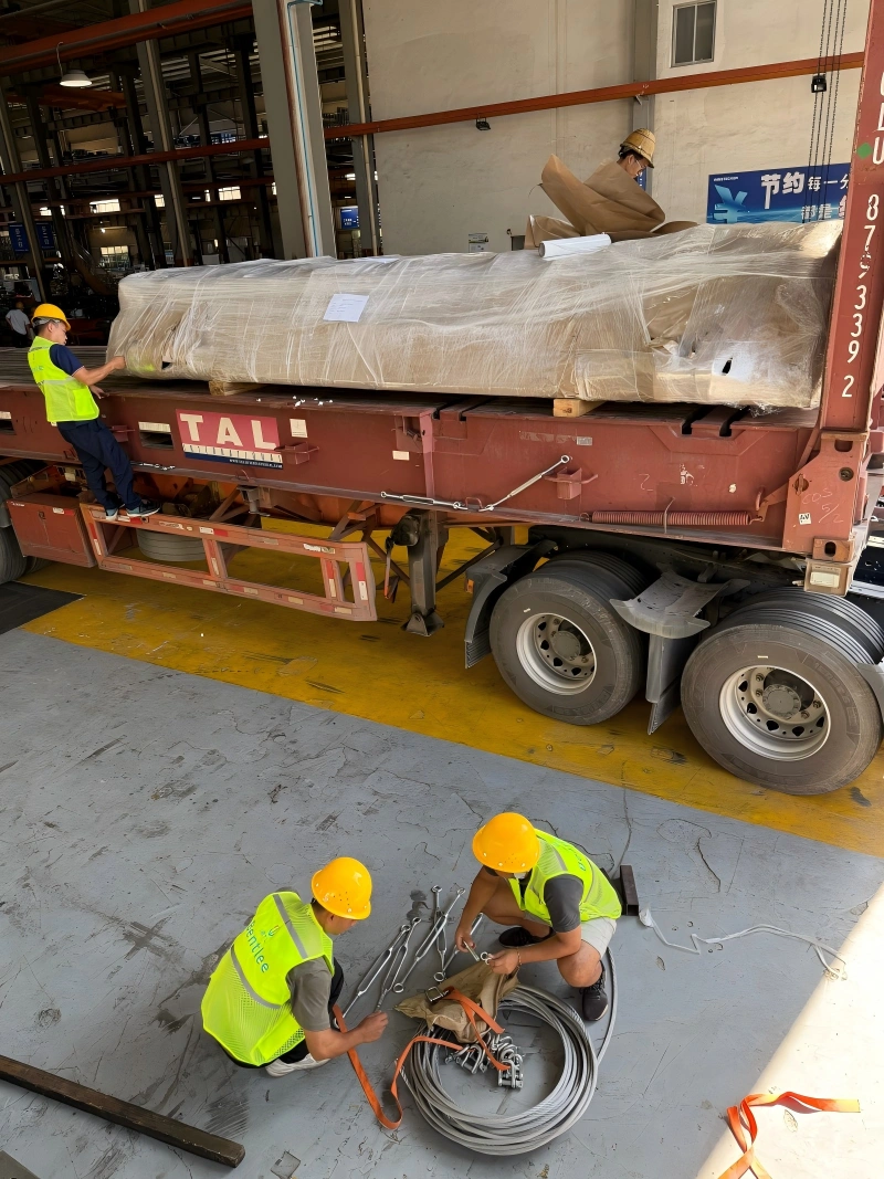 Logistics team preparing lashing equipment and securing materials for oversized cargo loading on a TAL flatbed trailer