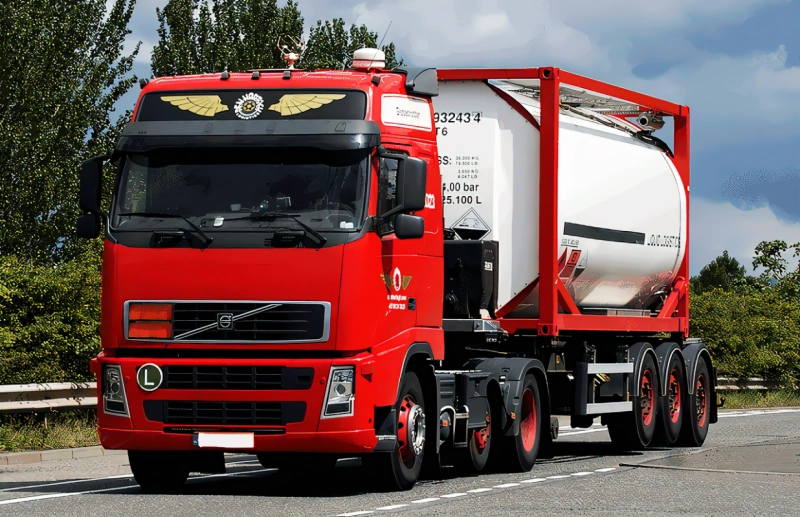 Red Volvo semi-truck hauling a white cryogenic tank container on a highway, representing road transport of refrigerated liquids under ADR regulations