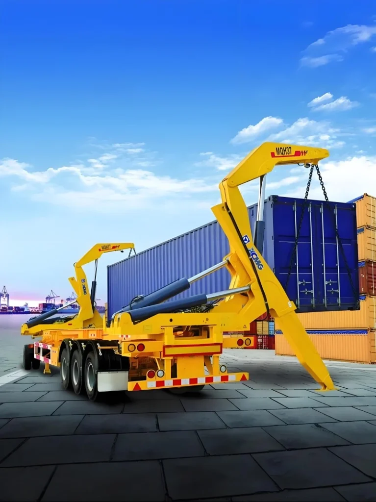 A bright yellow XCMG MQH37 side loader is shown in the process of lifting a blue shipping container from the ground at a busy port, with stacks of containers in the background.