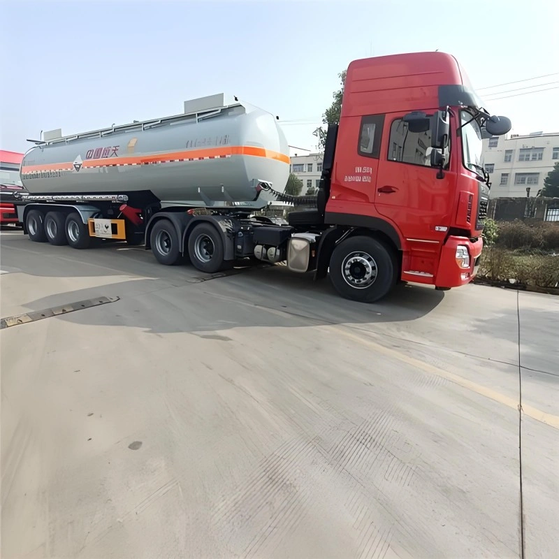 Red Zhongxin Hangtian chemical tanker truck with orange hazard markings, built for safe road transport of corrosive liquids and hazardous materials