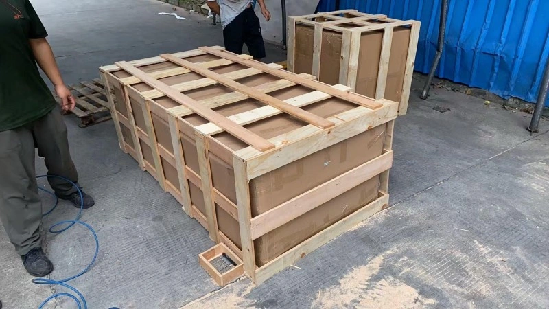 Multiple identical wooden crates lined up outdoors, showcasing scalable manufacturing and consistent quality for high-volume electronic component shipments