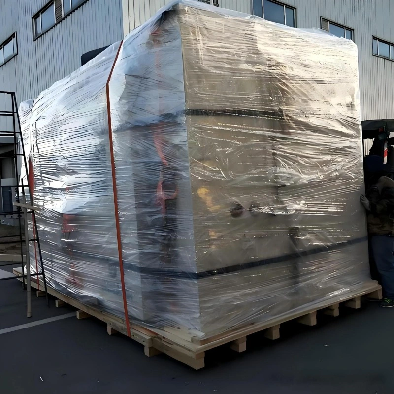 A mobile crane lifting a large, reinforced wooden export crate onto a truck bed, showcasing professional handling and structural integrity for oversized cargo logistics.