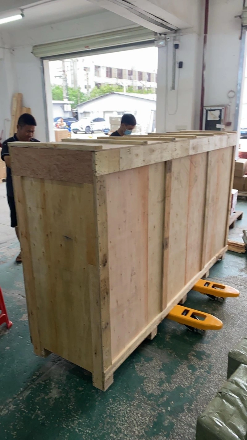 Workers assembling a large plywood crate with reinforced skids in a workshop, demonstrating professional packaging solutions for industrial equipment transport.