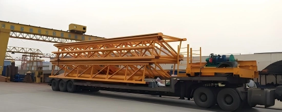 Multi-axle trailer transporting disassembled yellow gantry crane components, illustrating efficient loading orientation for complex steel structures.