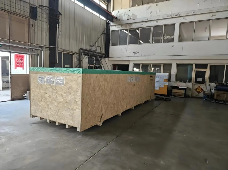 Forklift moving a large machine wrapped in silver aluminum foil vacuum bag, providing rust protection and moisture barrier for export logistics.