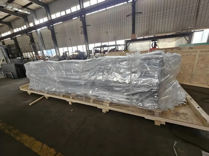 Large industrial equipment wrapped in clear vacuum plastic film on a wooden pallet, preventing moisture damage during ocean freight transport.