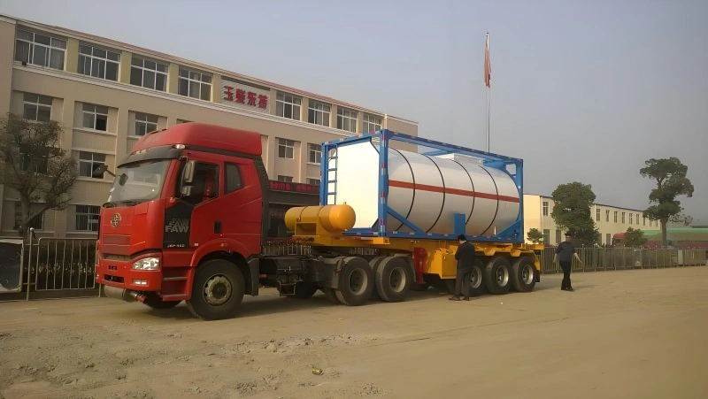 A red heavy-duty truck carrying a large white tank container for transporting liquid ammonium nitrate