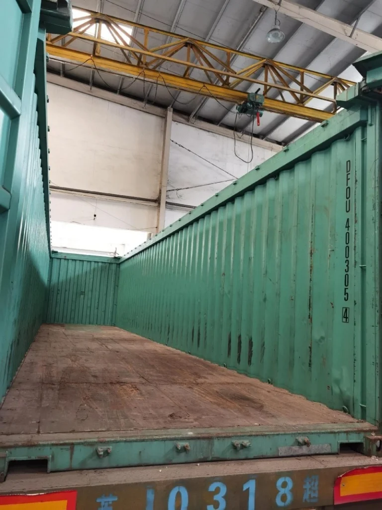Interior view of an empty green open-top container ready for loading, highlighting preparation steps in multimodal logistics planning.