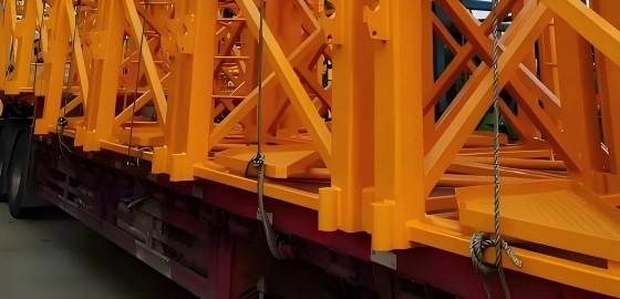 Close-up view of heavy-duty chains and binders securing yellow steel framework to a trailer bed, ensuring stability and safety during OOG transportation.
