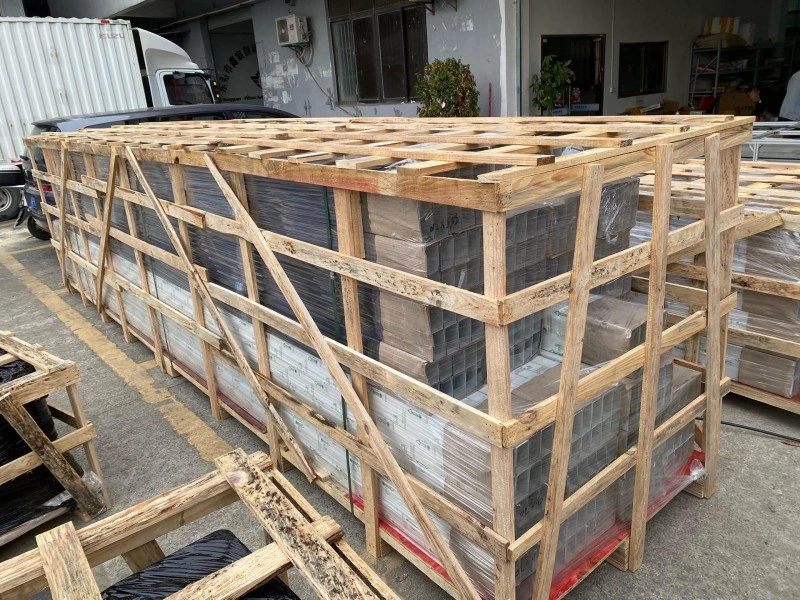 Long wooden crate with diagonal cross-bracing and shrink-wrapped contents, demonstrating engineered load distribution and export-ready construction