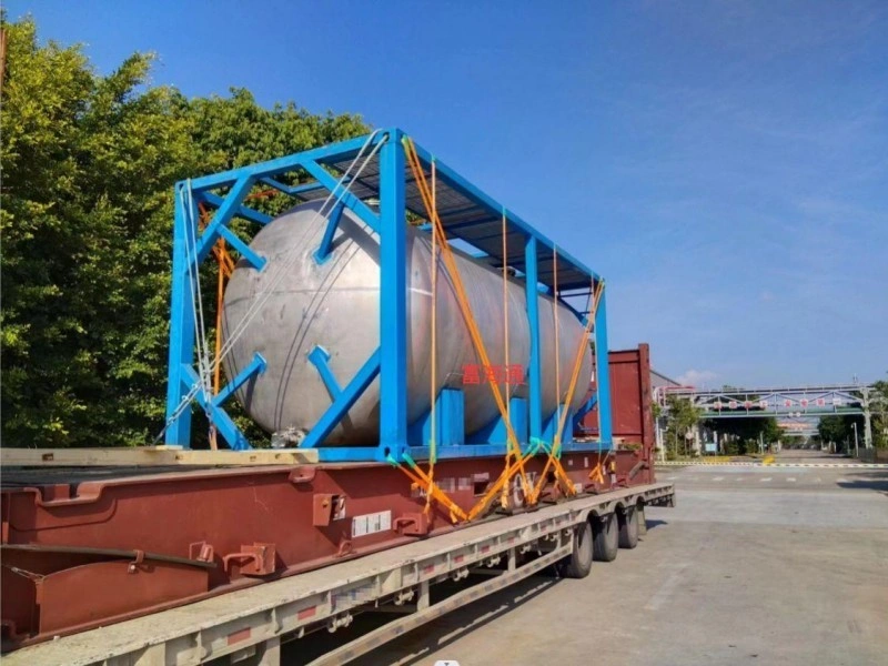 A large cylindrical tank securely mounted on a custom blue cradle and transported on a flatbed truck, with safety straps ensuring stability.