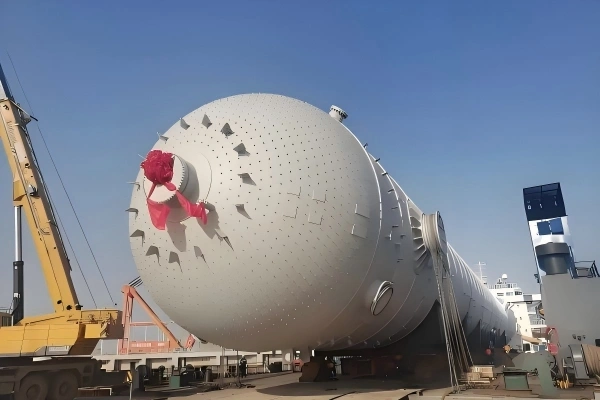 Close-up of a pressure vessel end-cap adorned with a red ribbon, signifying the successful arrival and handover of critical industrial equipment.