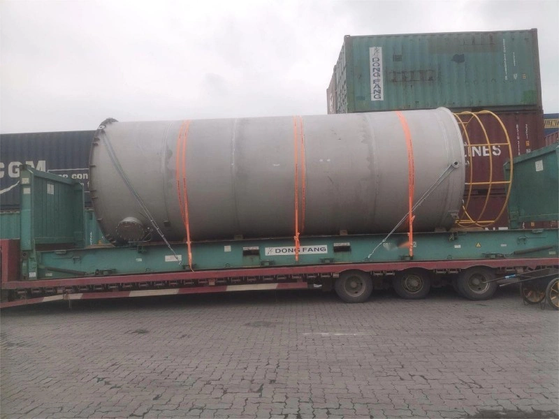 Industrial tank on a green Dong Fang flat rack container, surrounded by shipping containers, ready for intermodal shipment